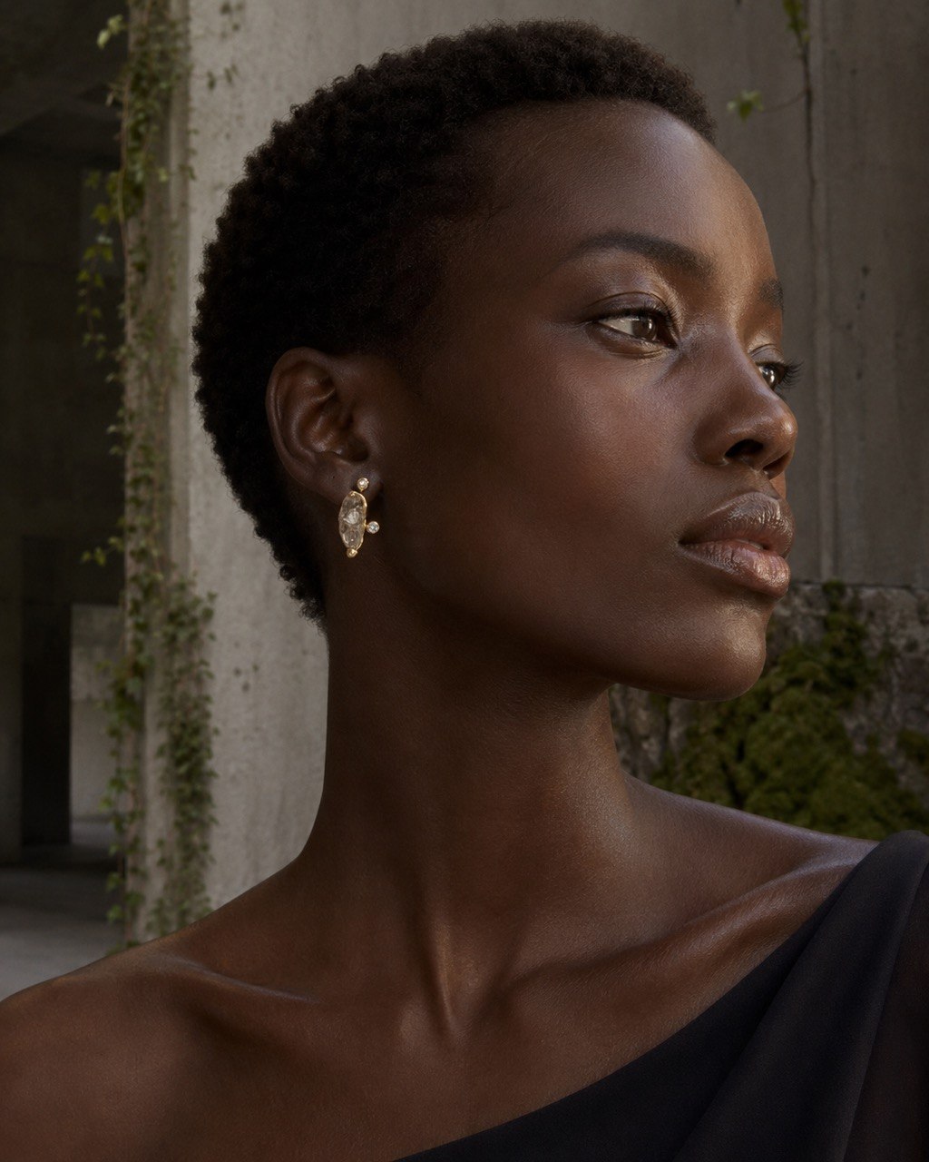 Portrait of a model wearing a one-of-a-kind stone and gold Alnami earring